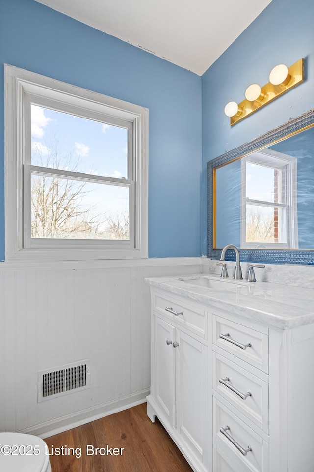 bathroom with a wainscoted wall, visible vents, a wealth of natural light, and vanity