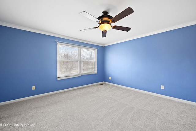 carpeted empty room featuring baseboards and ornamental molding