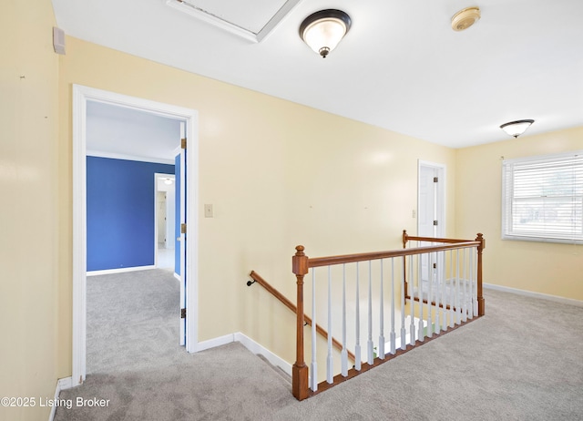 hall featuring baseboards, carpet flooring, and an upstairs landing