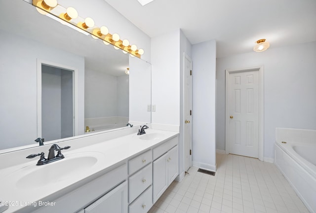 bathroom with double vanity, a sink, a bath, and tile patterned floors