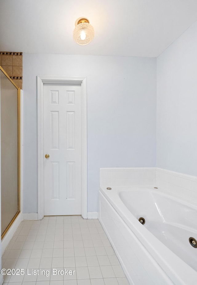 bathroom with a stall shower, tile patterned floors, baseboards, and a bath