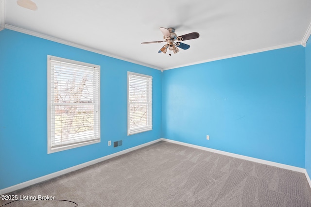 spare room with ceiling fan, carpet floors, visible vents, baseboards, and crown molding