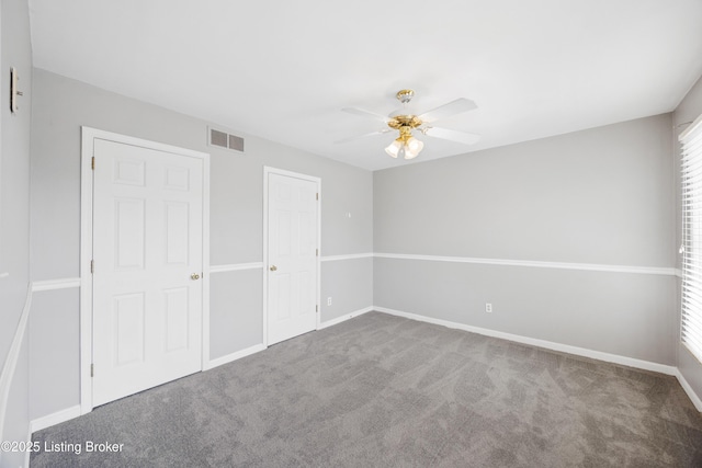 unfurnished bedroom featuring carpet, visible vents, ceiling fan, and baseboards