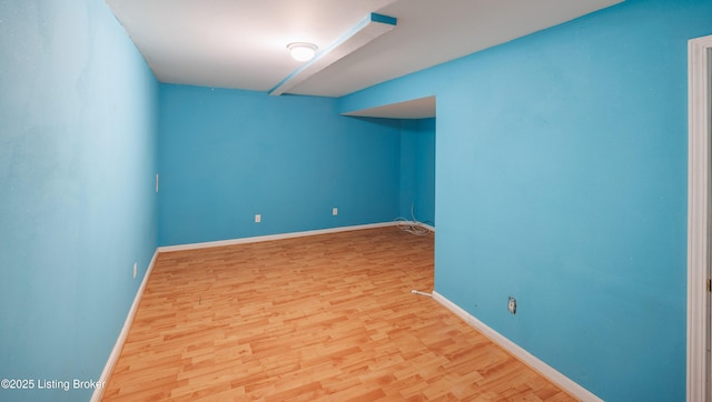 empty room with baseboards and wood finished floors