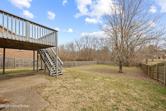 view of yard featuring a fenced backyard, a deck, and stairs