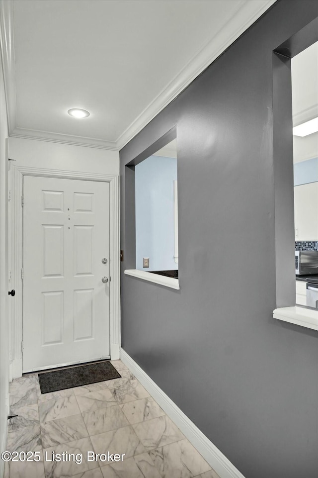 interior space featuring baseboards, marble finish floor, and crown molding