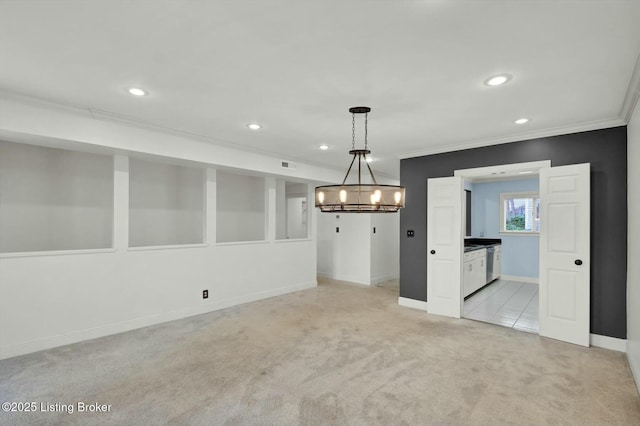 empty room featuring recessed lighting, light carpet, and crown molding