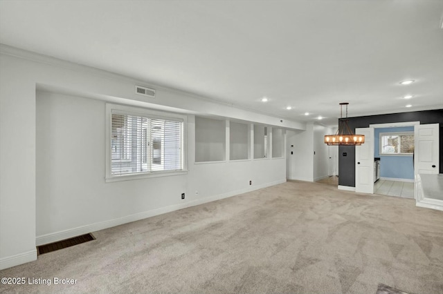 unfurnished living room featuring a wealth of natural light, visible vents, light carpet, and recessed lighting