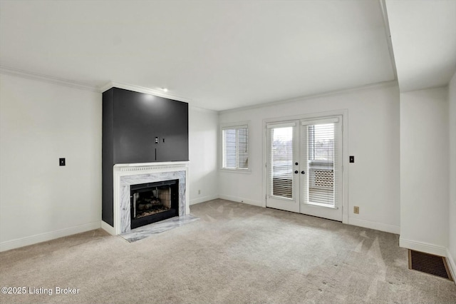 unfurnished living room with crown molding, visible vents, and carpet flooring