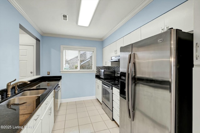 kitchen featuring under cabinet range hood, a sink, white cabinets, ornamental molding, and appliances with stainless steel finishes