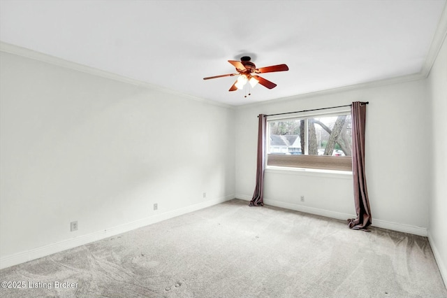 spare room featuring a ceiling fan, carpet flooring, crown molding, and baseboards