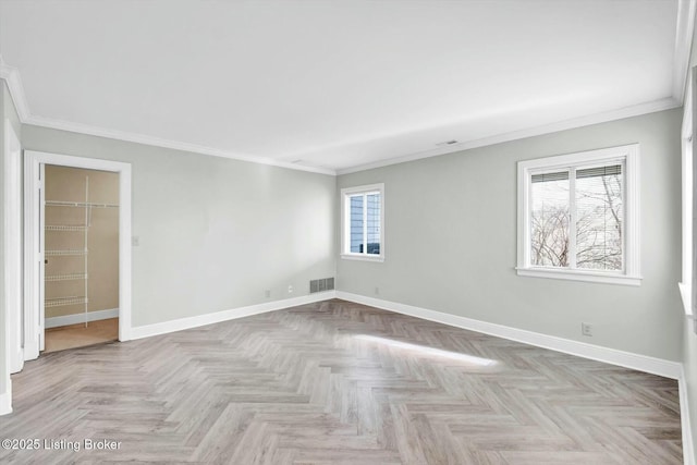 unfurnished room featuring ornamental molding, visible vents, and baseboards