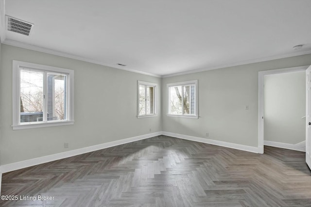 empty room with ornamental molding, visible vents, and baseboards