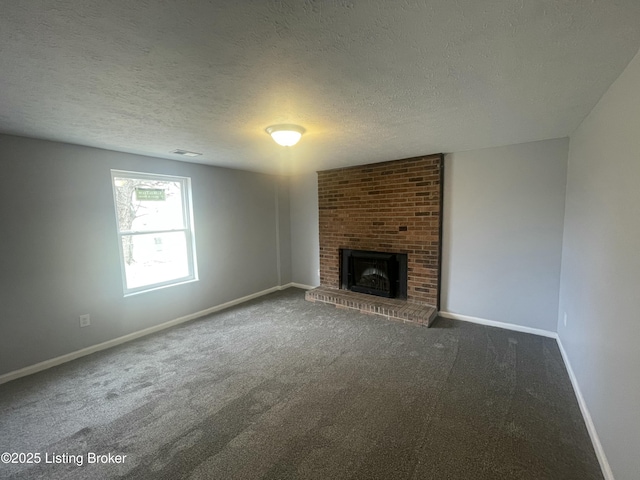 unfurnished living room featuring a textured ceiling, a brick fireplace, carpet flooring, and baseboards