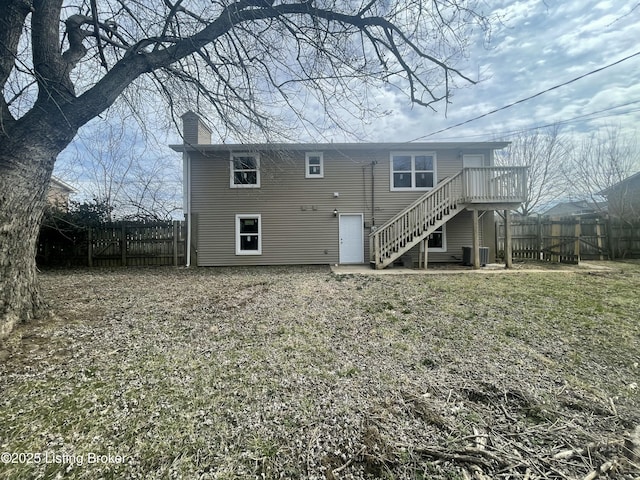 rear view of house with stairs, central AC, a chimney, and fence