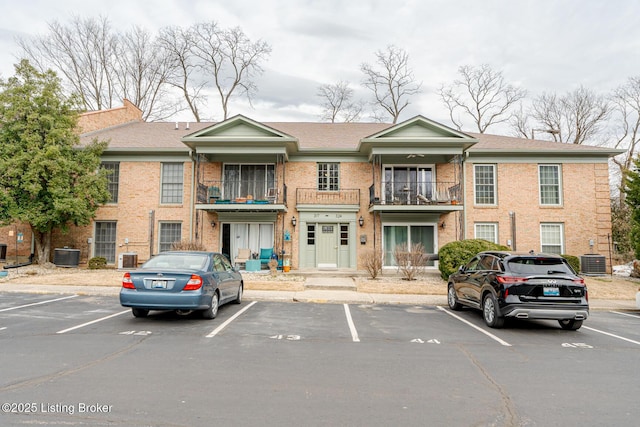 view of property featuring uncovered parking and central AC