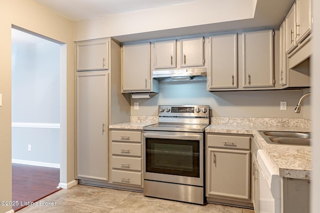 kitchen with stainless steel electric range oven, gray cabinetry, a sink, and under cabinet range hood