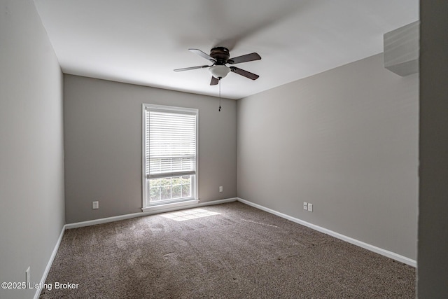 carpeted empty room with ceiling fan and baseboards