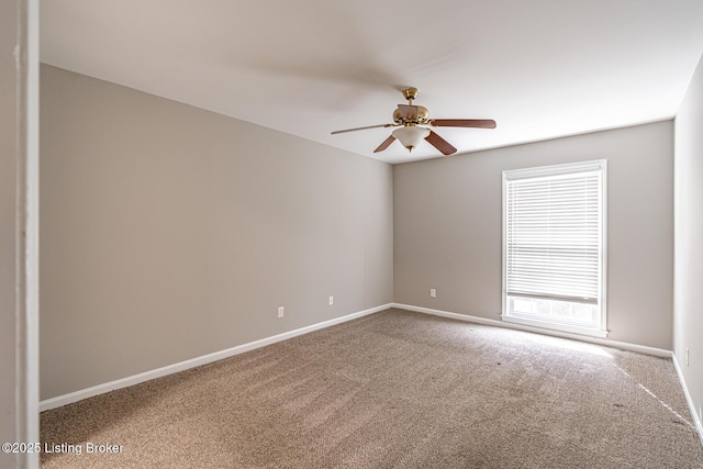 spare room featuring carpet, baseboards, and ceiling fan