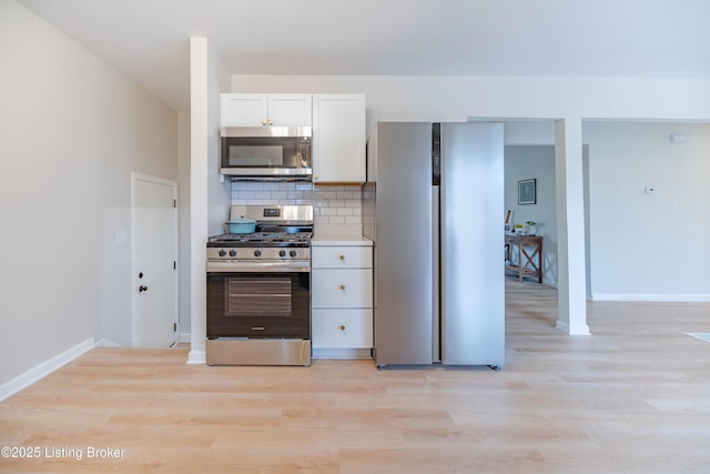 kitchen with appliances with stainless steel finishes, light wood-type flooring, decorative backsplash, and white cabinets