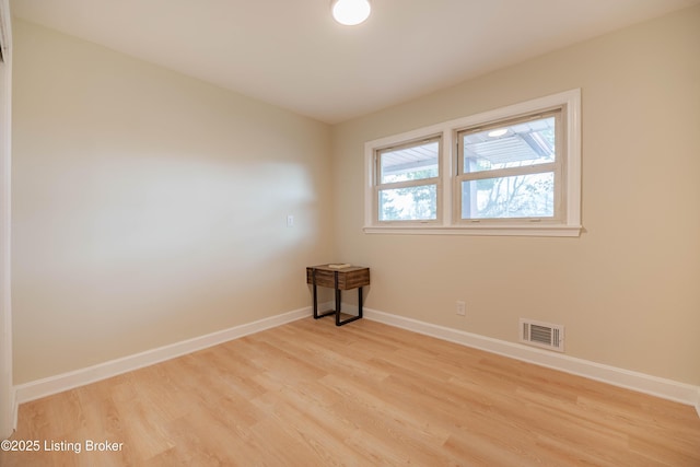 unfurnished room featuring light wood-style floors, baseboards, and visible vents