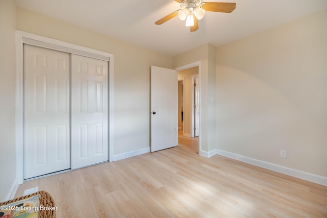 unfurnished bedroom with a ceiling fan, a closet, baseboards, and wood finished floors