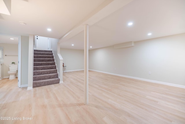 finished basement with light wood-style floors, recessed lighting, stairway, and baseboards