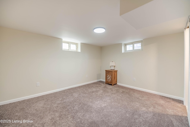 below grade area featuring a healthy amount of sunlight, baseboards, and carpet floors