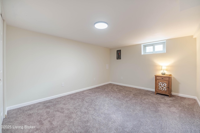 spare room with carpet, electric panel, and baseboards