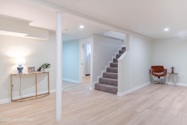 finished basement featuring light wood-style floors, recessed lighting, baseboards, and stairs