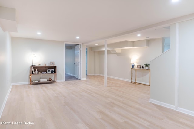 finished below grade area featuring light wood finished floors, recessed lighting, and baseboards