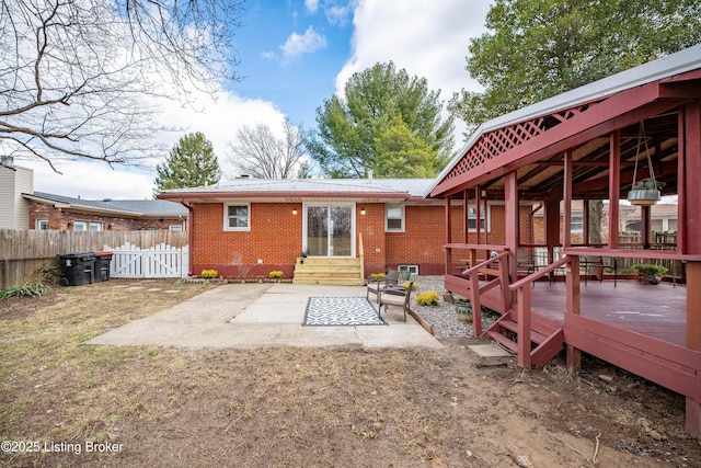 back of property featuring entry steps, a patio, metal roof, fence, and brick siding