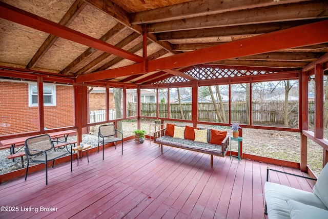 unfurnished sunroom featuring lofted ceiling and plenty of natural light