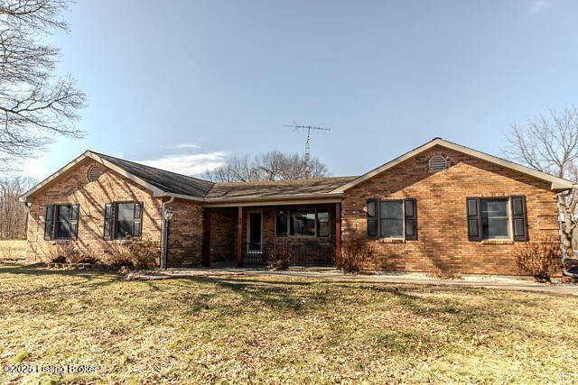 ranch-style house featuring a front yard, a porch, and brick siding