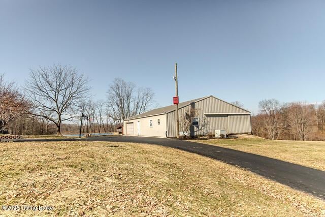 view of home's exterior with a garage, a chimney, an outdoor structure, and an outbuilding