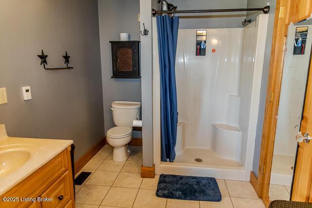 full bathroom featuring vanity, a shower stall, toilet, and tile patterned floors