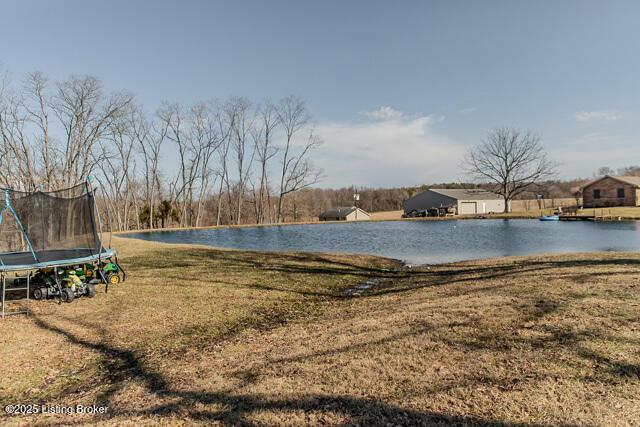 exterior space with a trampoline and a water view