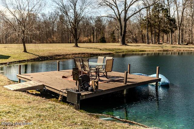 dock area with a water view and a yard