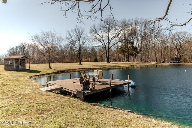 dock area with a lawn and a water view