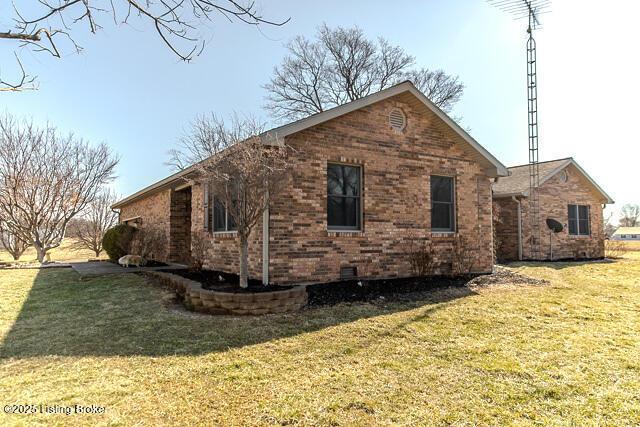 view of side of property with a lawn and brick siding