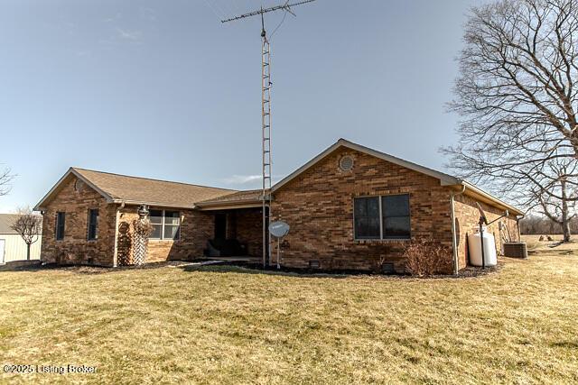 single story home with brick siding, central AC, and a front yard