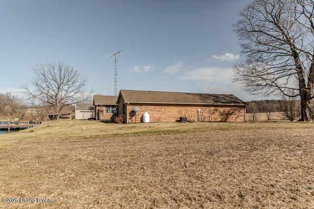 exterior space with central AC unit and a lawn