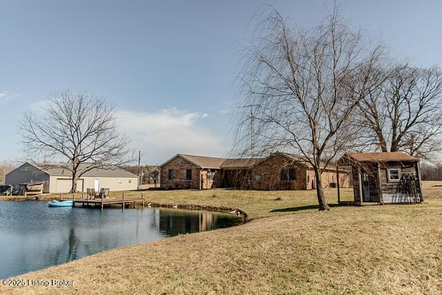 exterior space with a lawn, a water view, and an outdoor structure