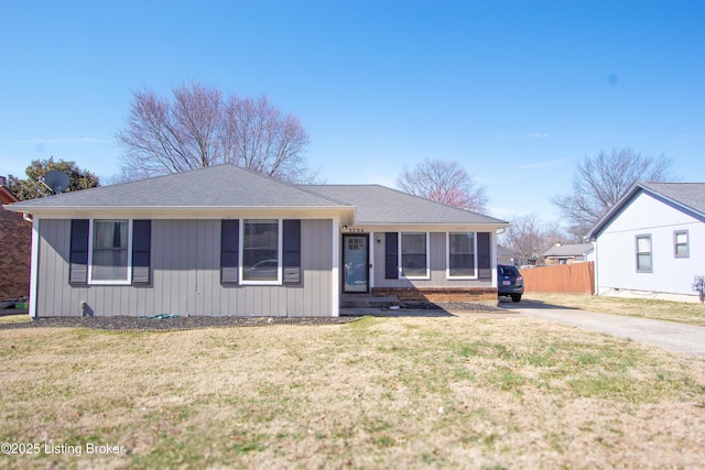 view of front facade featuring driveway, fence, and a front yard