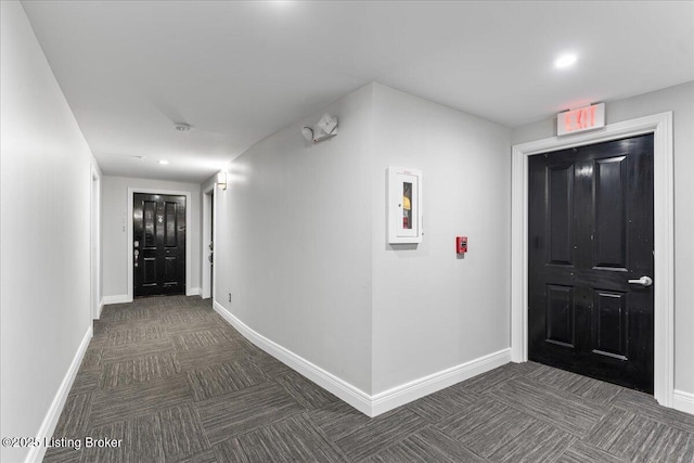 hallway with recessed lighting, baseboards, and dark carpet