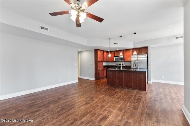 kitchen with dark countertops, visible vents, open floor plan, stainless steel appliances, and dark wood-style flooring