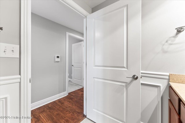 bathroom featuring vanity, baseboards, and wood finished floors