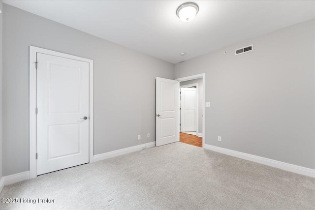 unfurnished bedroom featuring baseboards, visible vents, and carpet floors