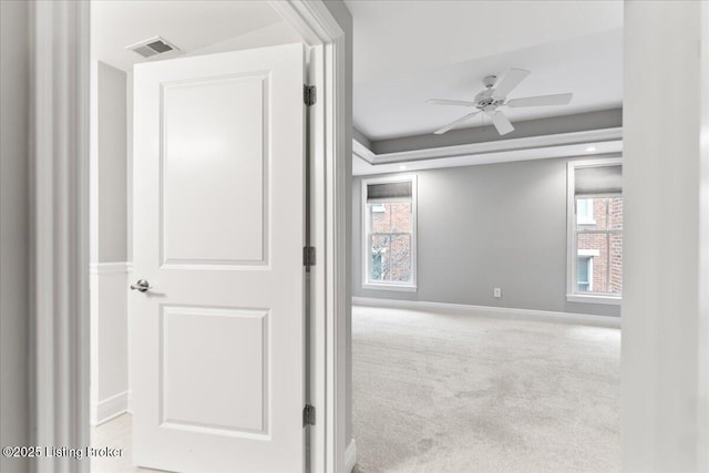 corridor featuring visible vents, baseboards, and carpet