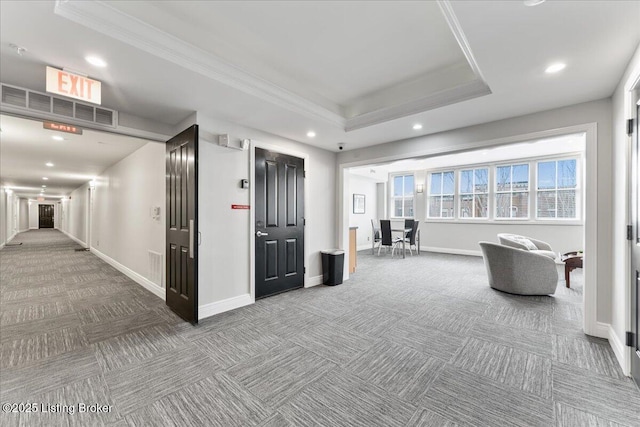 hall featuring recessed lighting, a tray ceiling, baseboards, and carpet flooring